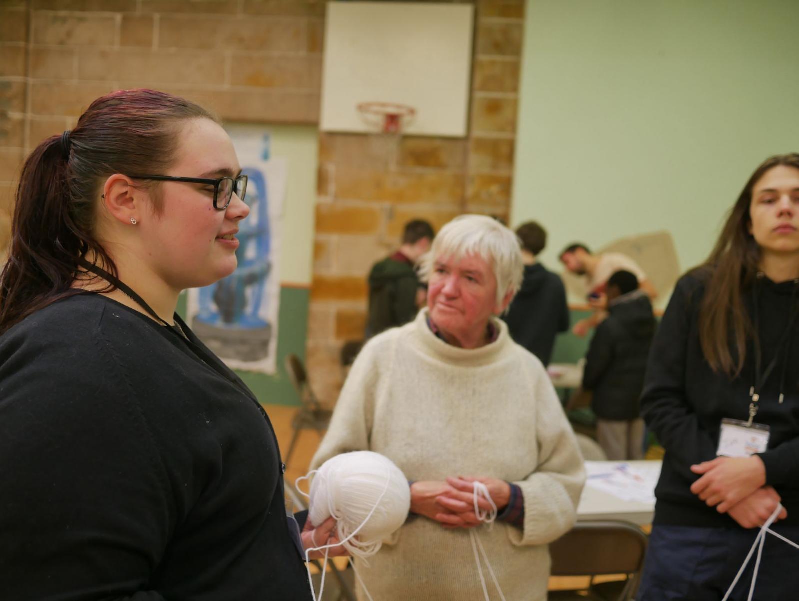 Young person leading a string game activity at a Community Outreach Day.