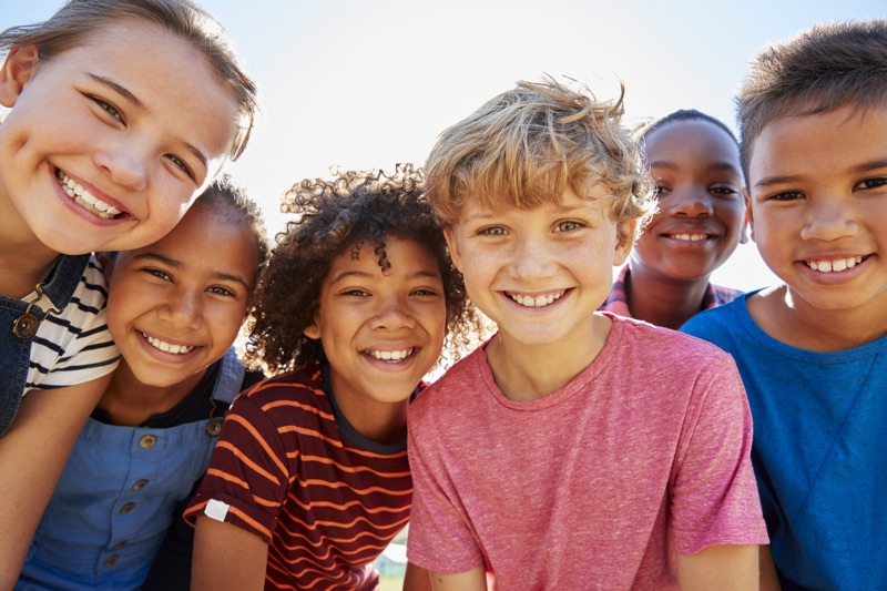group photo of children smiling in the sunshine