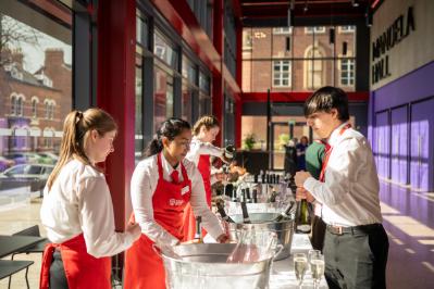 Image shows University hospitality staff serving drinks at the drinks' reception