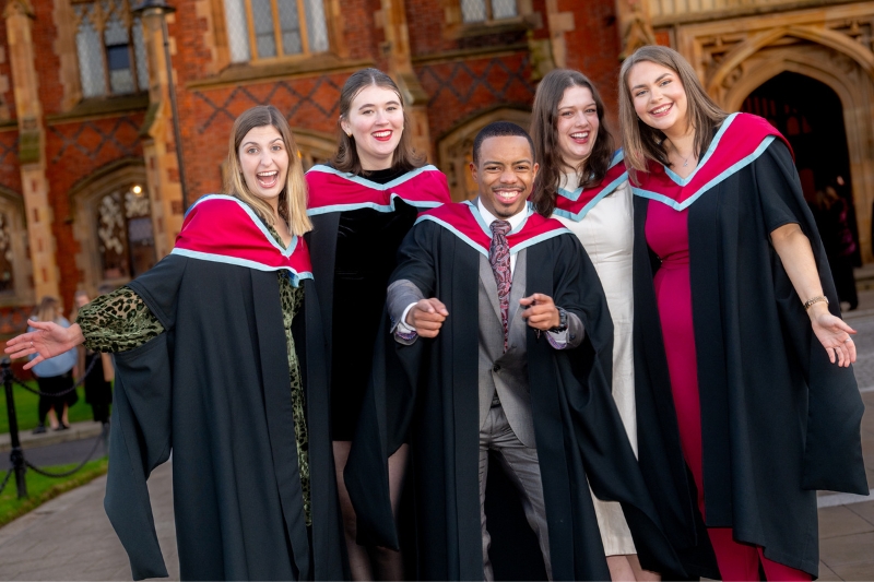 five smiling new graduates celebrating