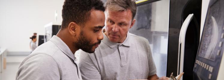 mature man explaining equipment to a younger colleague or visitor