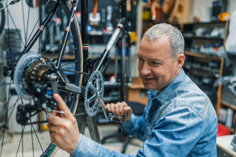 man servicing a bike in a bike shop