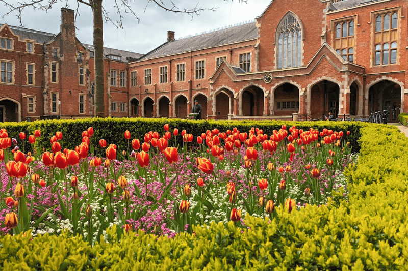 greenery and colourful flowers in the quadrangle of a Victorian-era redbrick building