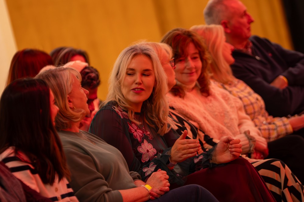 row of seated people chatting at an indoor event