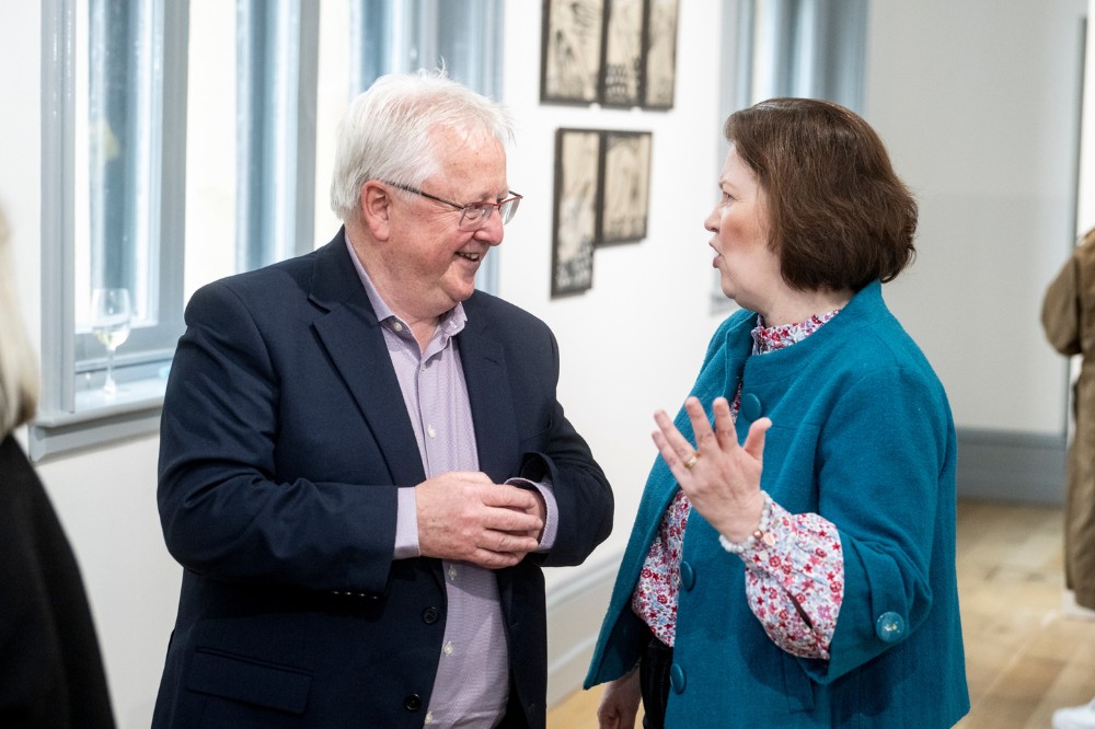 man and woman chatting in an art gallery