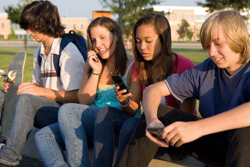 teens sitting in a park in early evening sun