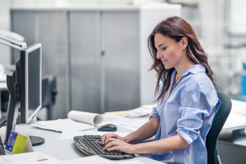 woman using desktop computer in a bright office space